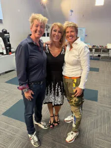Three attendees standing together at a leadership or training event.