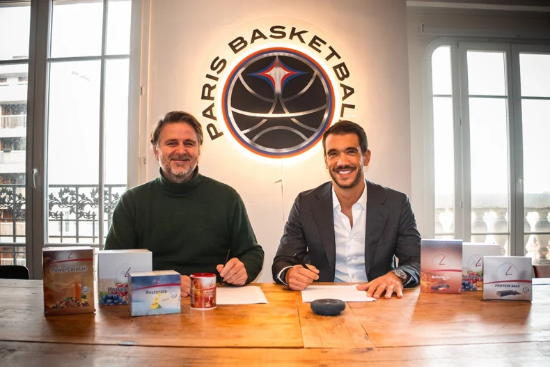 In this image released on Wednesday, December 10, 2025, Jérôme de Chaunac (left), Chief Business Officer of Paris Basketball, and Adrien Rincheval (right), Chief Sales Officer of PM-International, the developer of the FitLine products, are signing the contract for the new partnership between FitLine and Paris Basketball. [PM-International AG/News Aktuell via AP Images]
