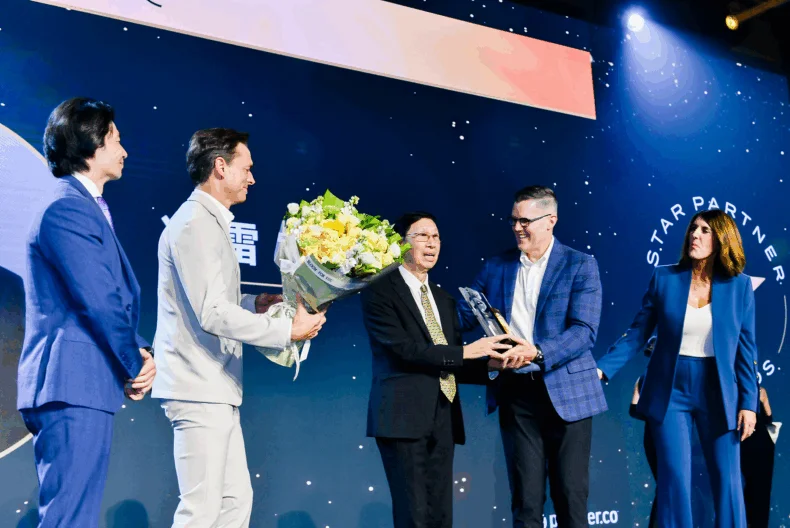 Dr. Feng Lei receiving the 2025 Partner.Co Vision Award on stage with company leadership