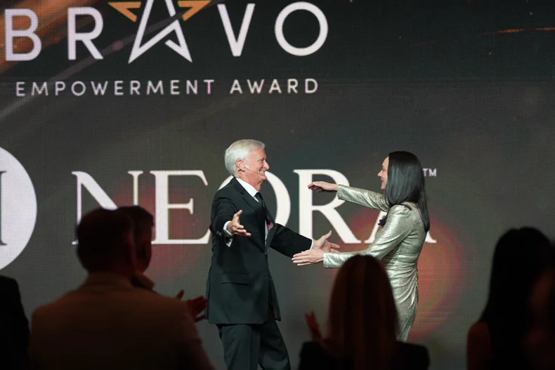 Neora is honored with the inaugural Bravo Empowerment Award at the April 2026 DSN Global100. Pictured: Neora Co-CEO Amber Olson Rourke and Direct Selling News CEO Stuart Johnson.