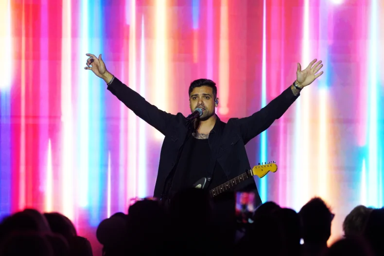 Pastor Chandan Bangar leading worship with guitar at Bravenly Global BNC26 conference