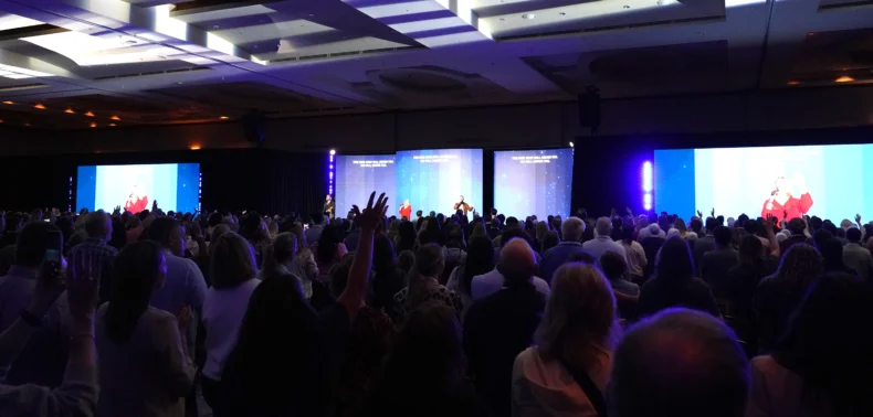 Attendees standing during optional morning worship service at Bravenly Global BNC26 conference