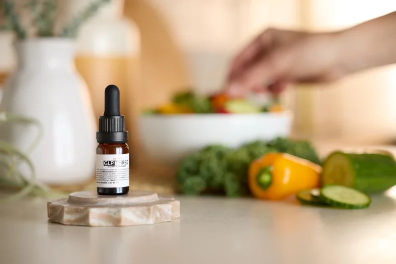 GLP THREE metabolic wellness supplement alongside healthy lifestyle foods