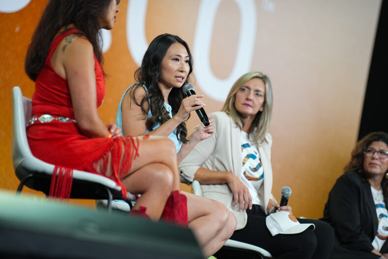 Becky Zheng speaking on stage at a Partner.Co leadership event