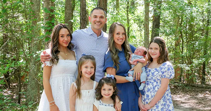 Joe and Chana Navarro with their five children outdoors in a family photo