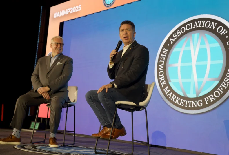 Ryan Chamberlin speaking on stage at ANMP event with Garrett McGrath