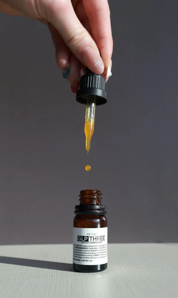 GLP THREE™ dietary supplement bottle with dropper showcasing natural GLP-1 support formula
