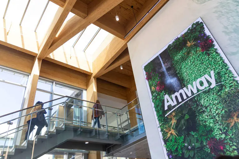 Amway headquarters interior with employees walking, representing the new Davenport University scholarship partnership.