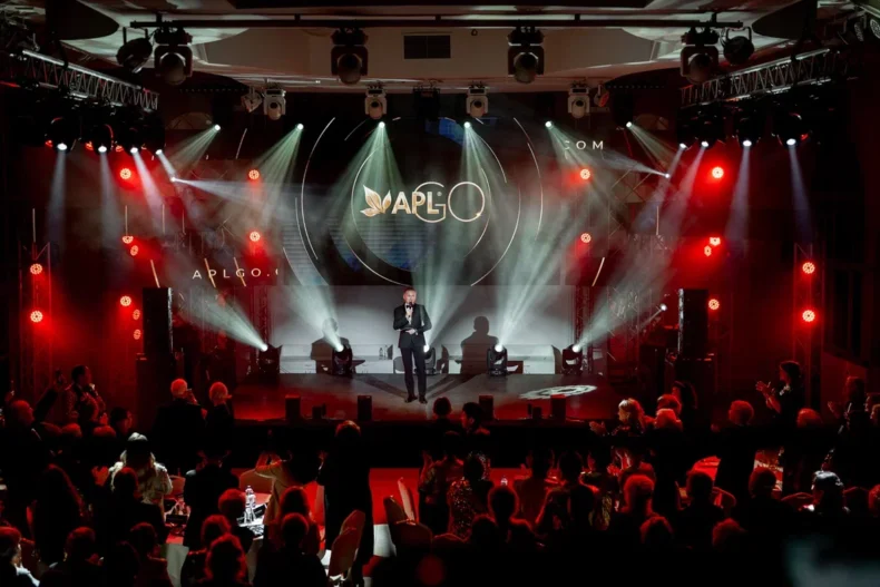 APLGO 20th anniversary celebration stage with Sergey Kulikov addressing leaders and guests.