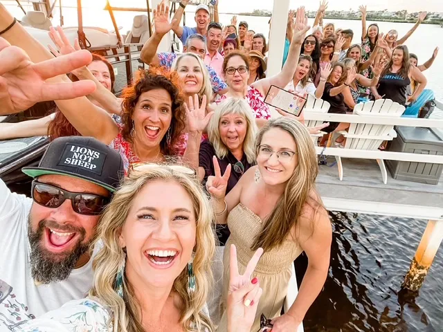 Dr. Dana McGrady smiling with her team and community during a waterfront gathering, part of the Amare Global women’s wellness and wealth movement.