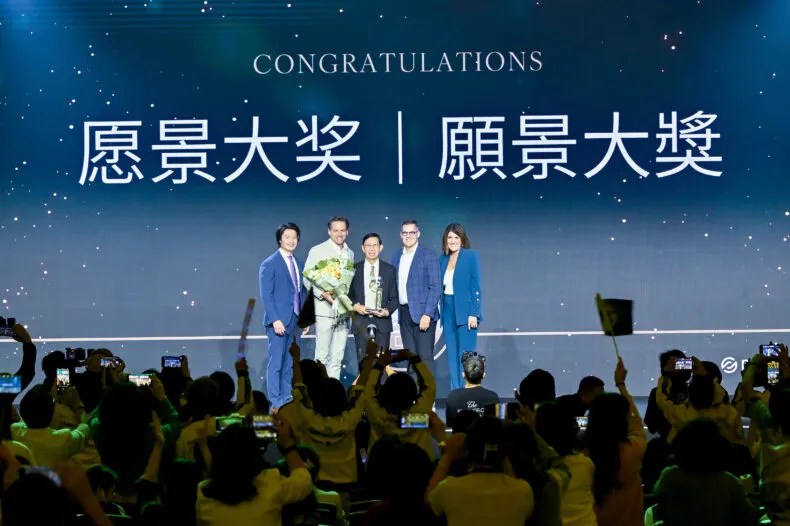 Dr. Feng Lei receiving the 2025 Partner.Co Vision Award on stage with company leadership in Macau