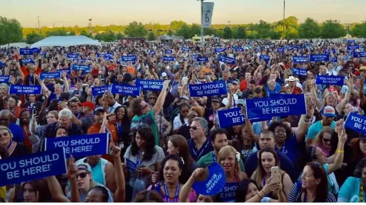 Large crowd holding DreamTrips “You Should Be Here” signs at an outdoor event