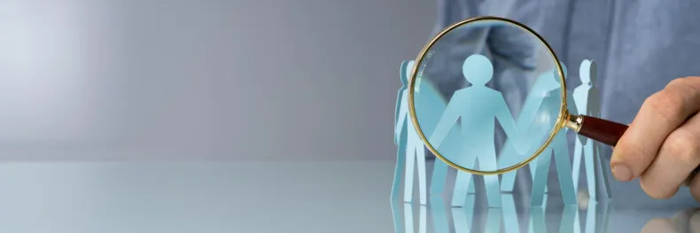 Magnifying glass highlighting paper cutout people representing different DRIVE types