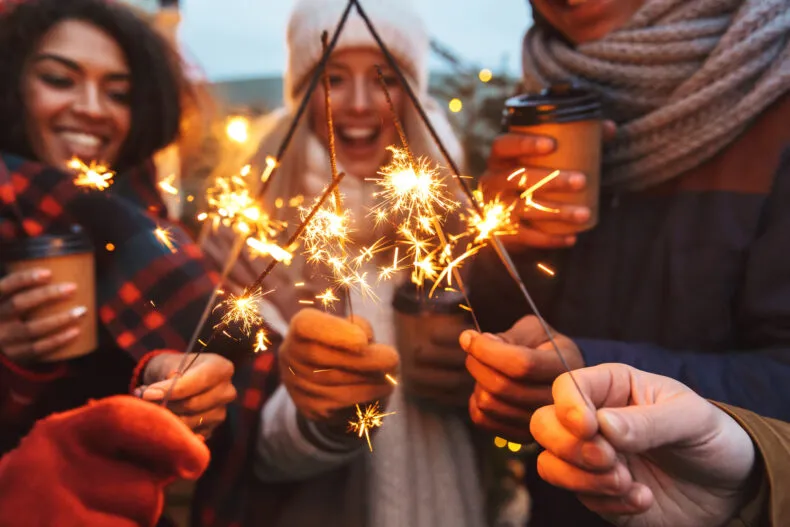 People holding sparklers together during a festive celebration