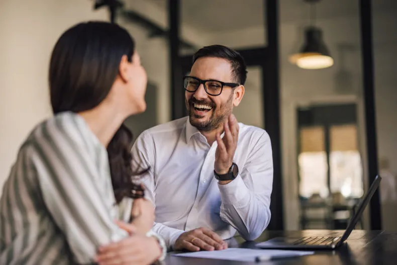 Man and woman having a friendly, engaging conversation in an office setting