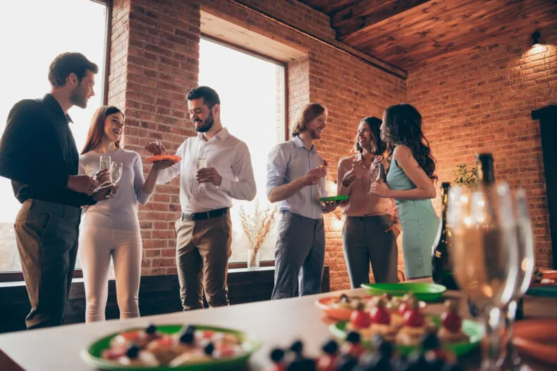 People mingling and talking at a holiday party