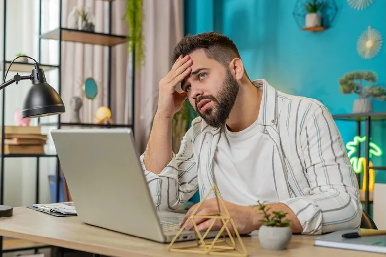 Entrepreneur feeling frustrated while reviewing business results on laptop