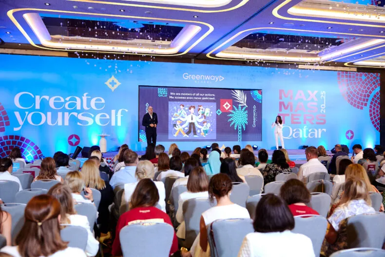 Greenway MaxMasters Qatar event with speakers onstage and a full audience
