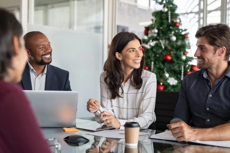 Business team meeting with a Christmas tree in the background