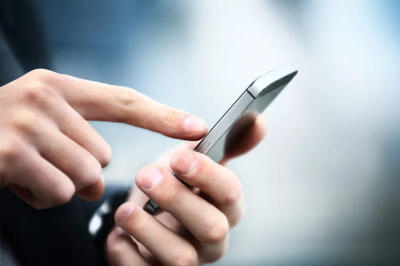 Close-up of a person using a smartphone to type or tap a message