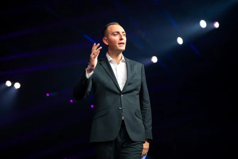 Kris Kamras speaking on stage at a major Zinzino event