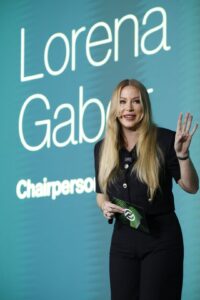 Lorena Gabor speaking in front of a large display showing her name and title