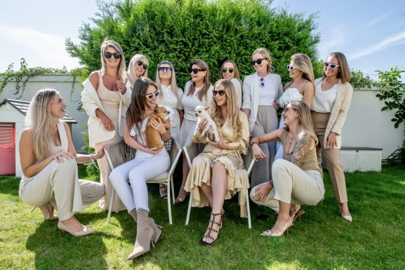 Lorena Gabor and her team smiling together outdoors in a garden setting