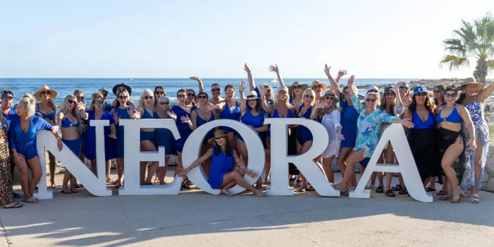 Neora Brand Partners posing with Neora sign Cabo