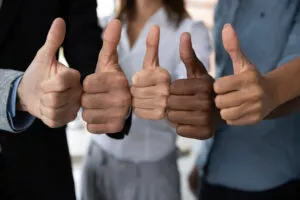 Group of people showing thumbs up symbolizing consistency and team alignment