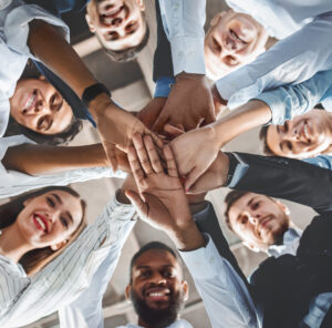 Group of people stacking hands together as a team
