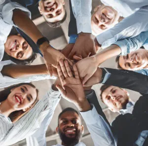 Group of people stacking hands together as a team