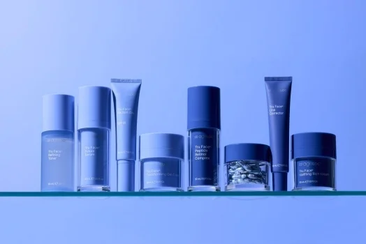 Nu Skin Tru Face skincare products displayed on a glass shelf with minimal, blue-toned packaging.