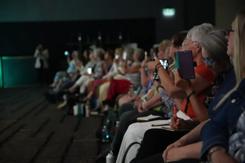Front row audience at Partner.Co Connect Calgary recording the stage with phones
