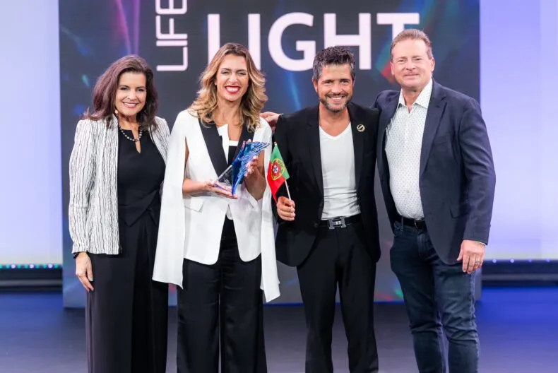 Paulo and Liliana Alves receive award and recognition from Founder David Schmidt and President Meredith Berkich on stage at LifeWave event.