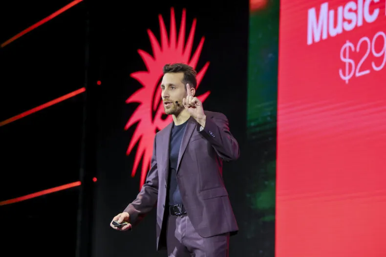 Stefano Orrù presenting at a network marketing event while raising a finger to emphasize a point