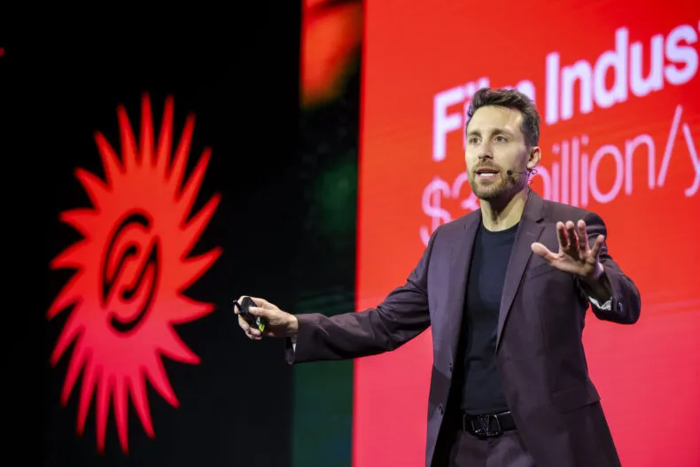 Stefano Orrù speaking energetically onstage at renowned industry event.