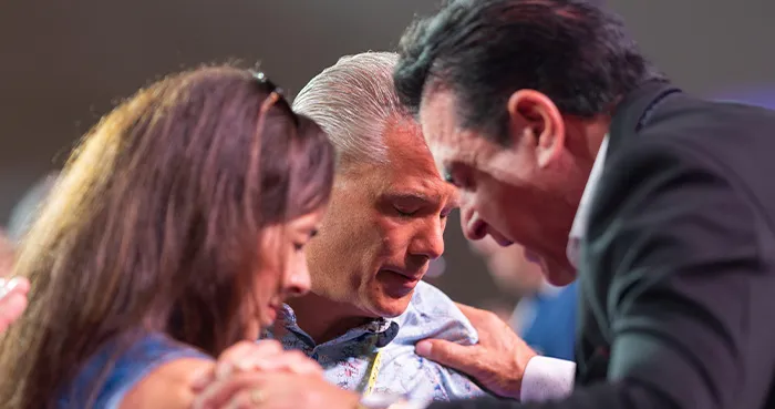 Steve Merritt praying with attendees