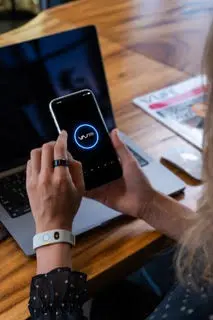 Vyvo AI app open on a smartphone, paired with wearable technology on user’s wrist.