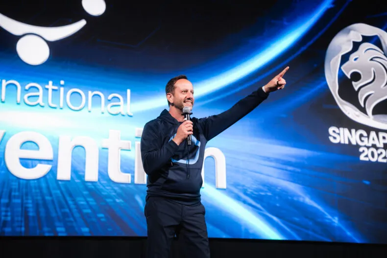 Alessandro Senatore pointing while speaking on stage at the Vyvo International Convention 2025