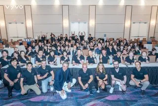 Vyvo leadership team poses together in matching black shirts at a conference venue.