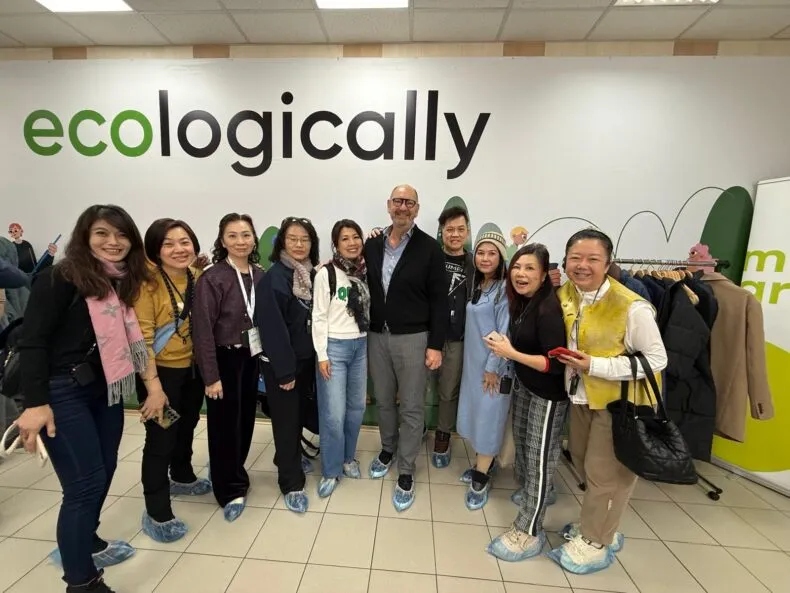 Yvonne Yen with Greenway Global leaders and distributors in front of eco-conscious banner, promoting sustainable business growth.